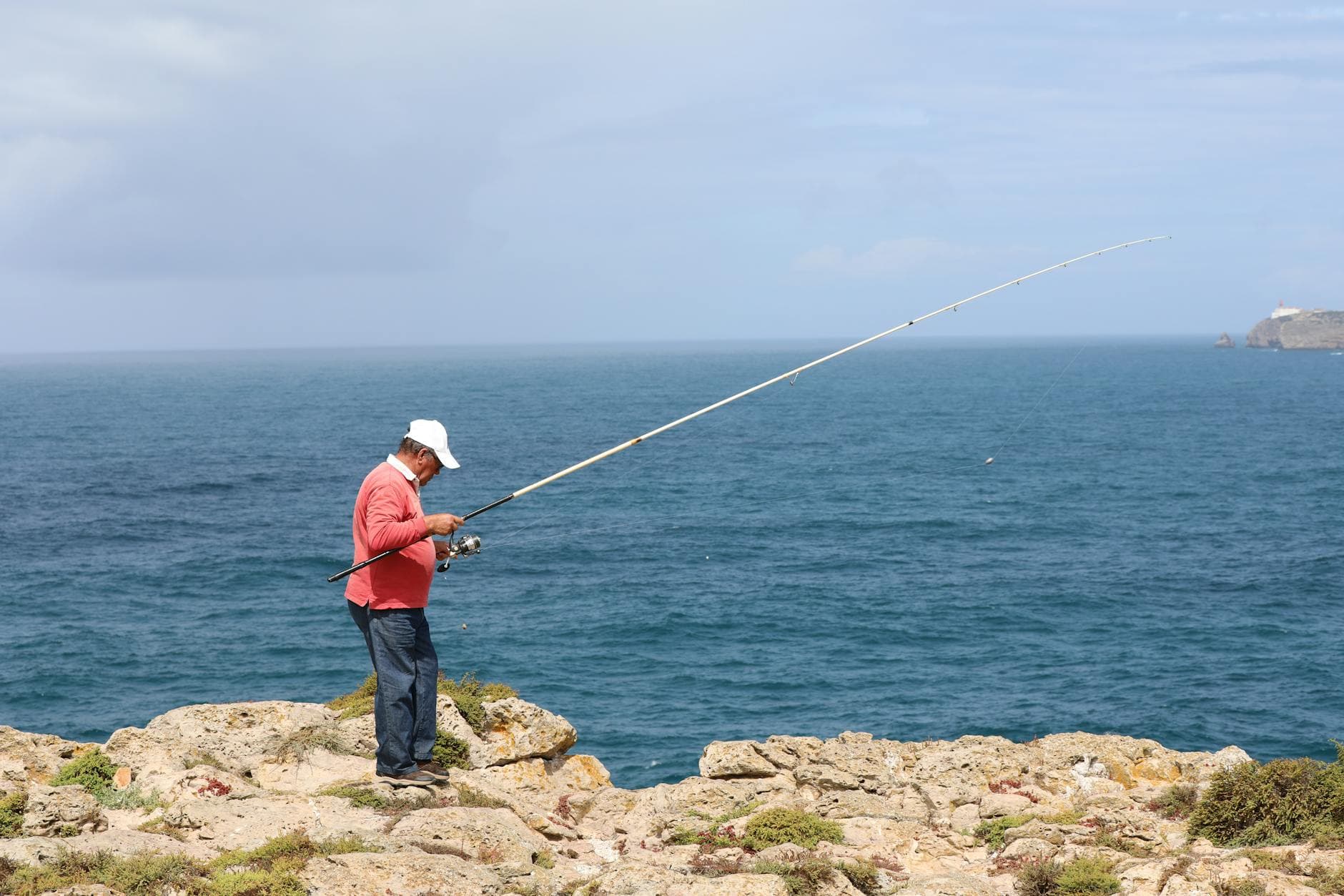 Pêcheur avec sa canne au bord de l'eau